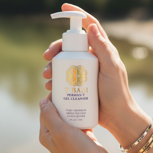 Hand holding a TBAHI gel cleanser bottle with a blurred natural background
