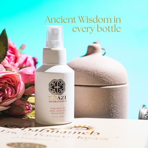 A white spray bottle labeled TEAZI HYDRATION 1 with a pump dispenser, styled on a surface with pink roses, a beige ceramic pot, and a turquoise background. Text at the top reads 'Ancient Wisdom in every bottle'.